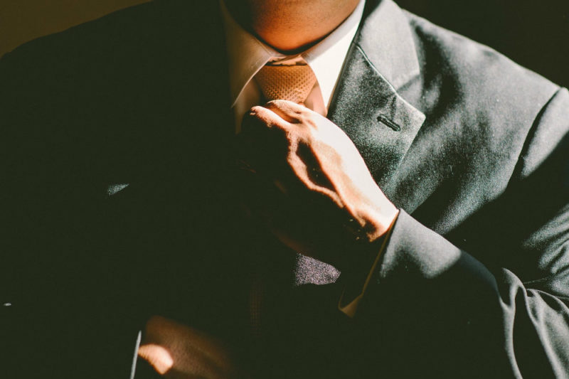 Guy In Suit Adjusting Tie