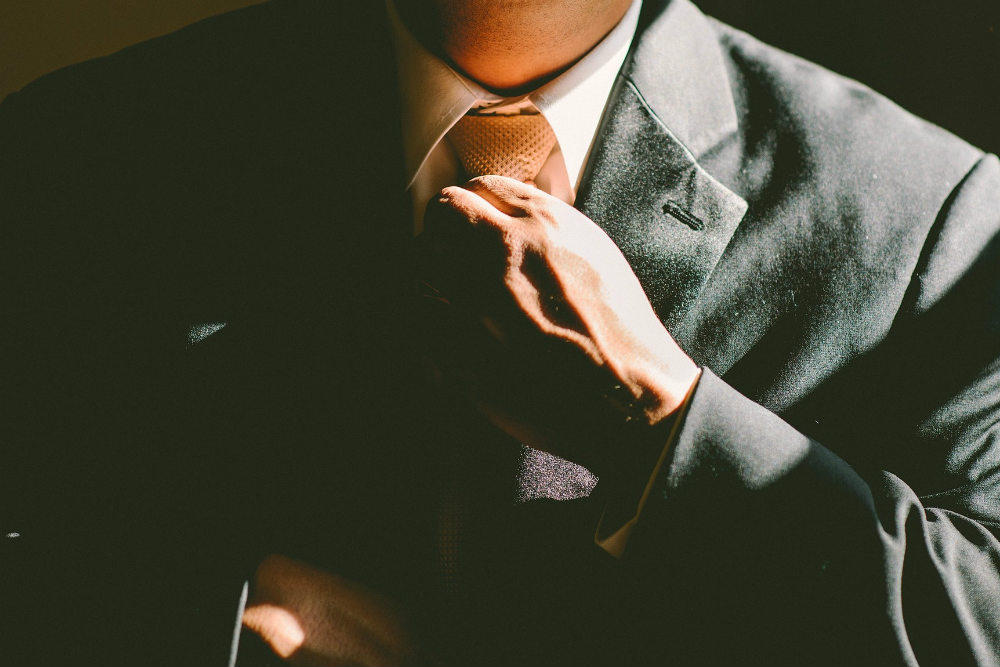 Guy In Suit Adjusting Tie