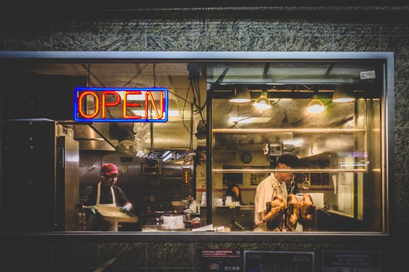 Exterior of small business with neon open sign in window